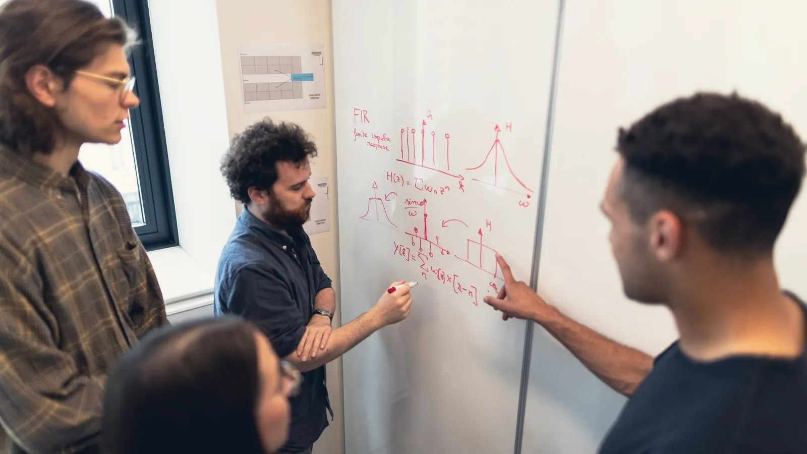 Engineers sketching a diagram on a whiteboard